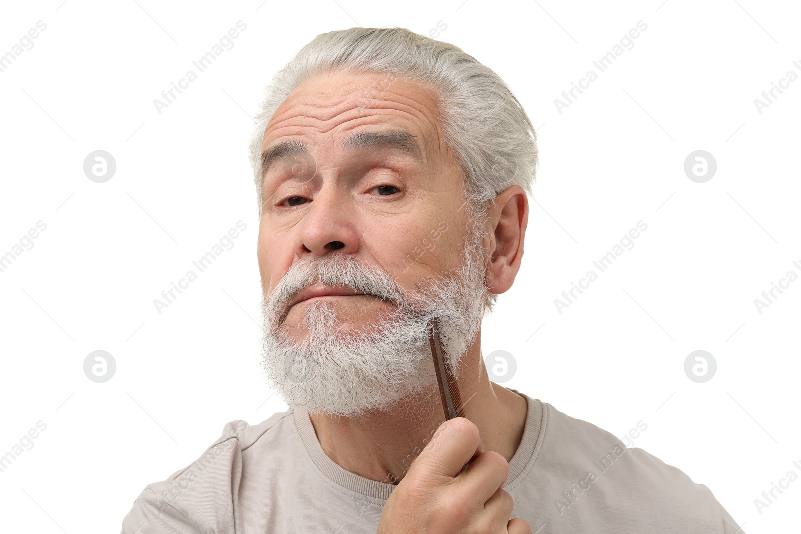 Photo of Senior man combing beard on white background