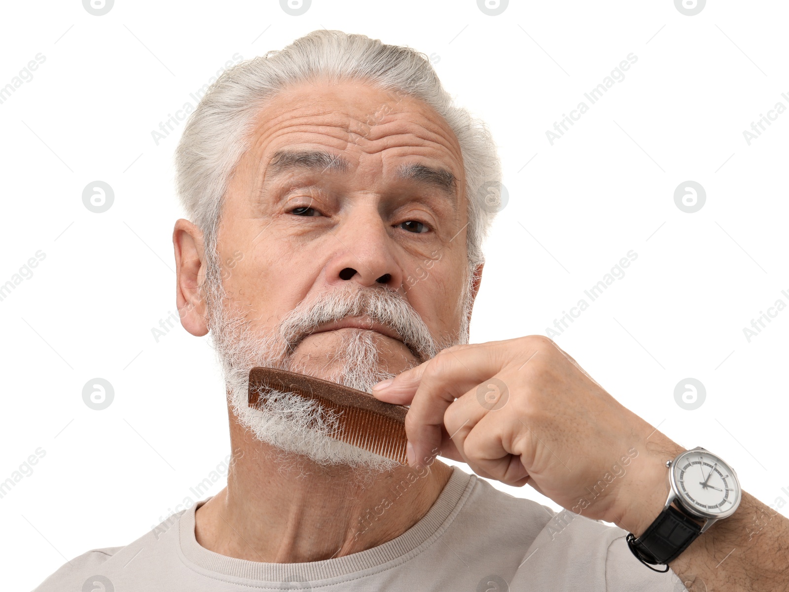 Photo of Senior man combing beard on white background