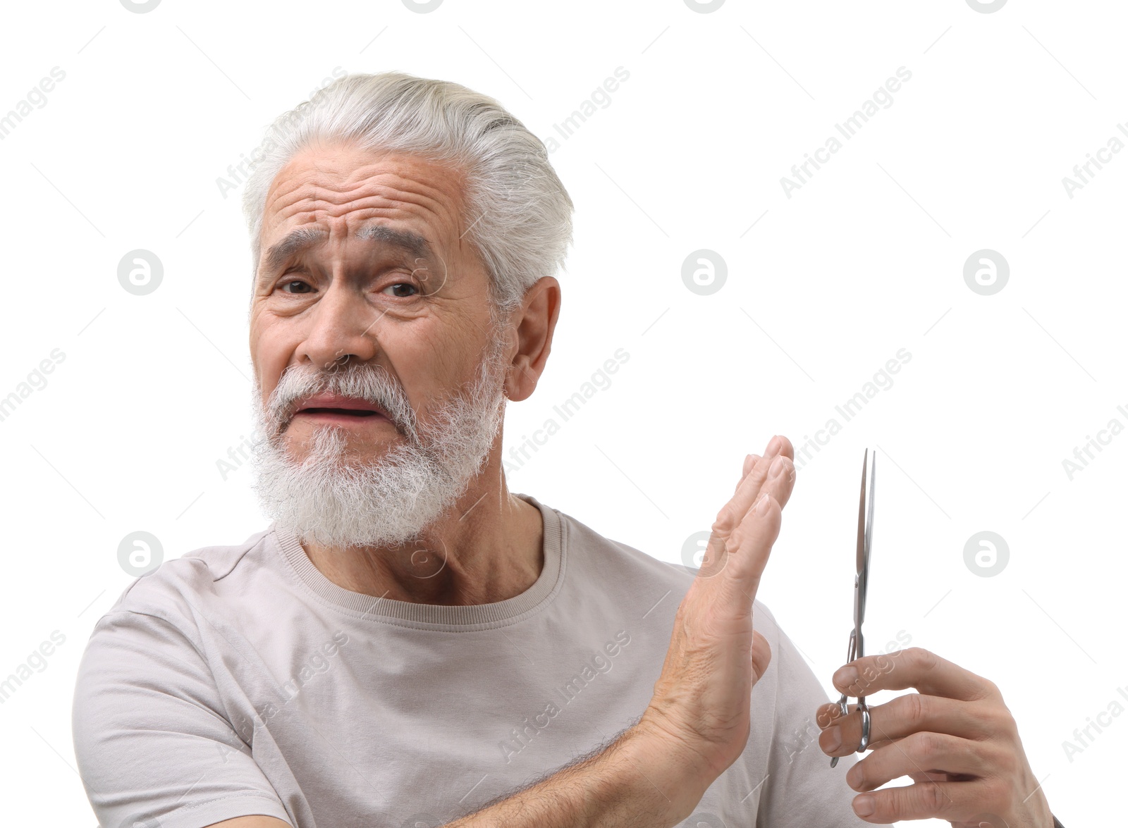 Photo of Bearded senior man with scissors making stop gesture on white background