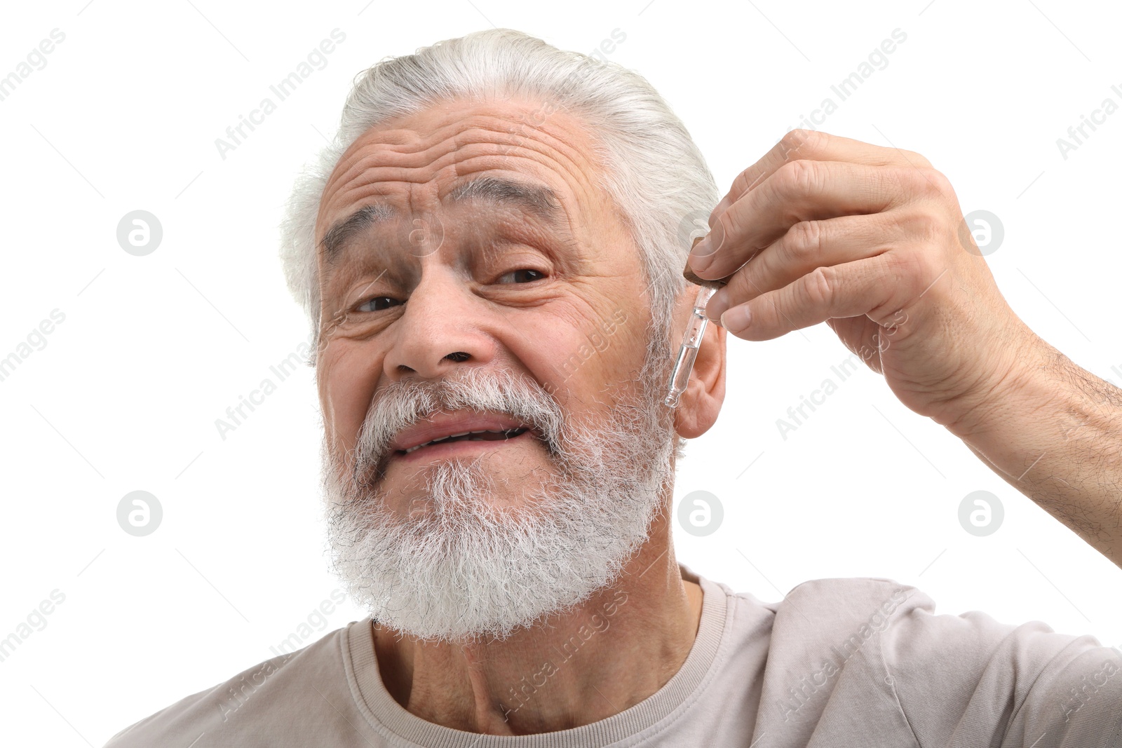 Photo of Senior man applying serum onto his beard on white background