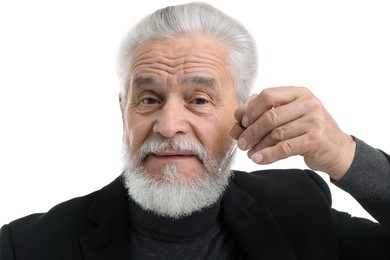 Photo of Senior man applying serum onto his beard on white background