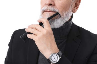 Senior man combing beard on white background, closeup