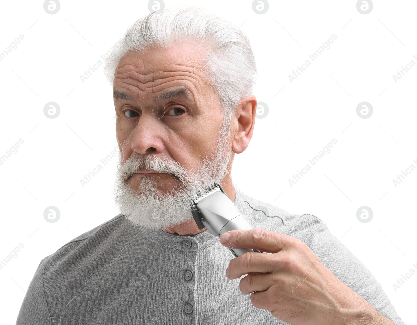 Photo of Senior man trimming beard on white background