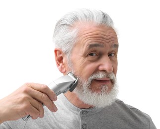 Senior man trimming beard on white background