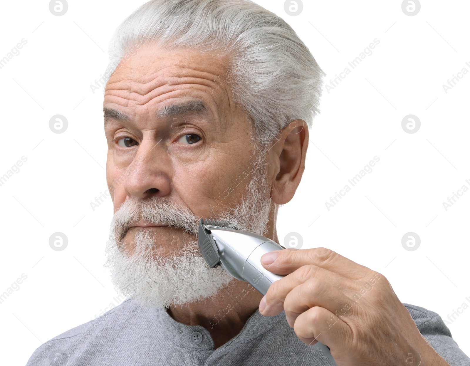 Photo of Senior man trimming beard on white background