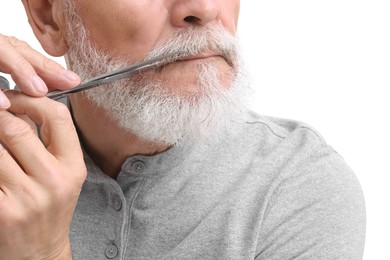 Photo of Senior man trimming beard with scissors on white background, closeup