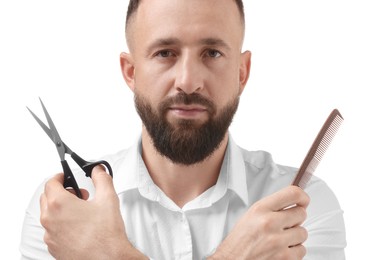 Photo of Bearded man holding comb and scissors on white background