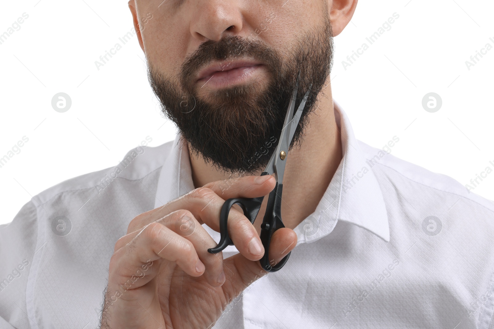 Photo of Man trimming beard with scissors on white background, closeup