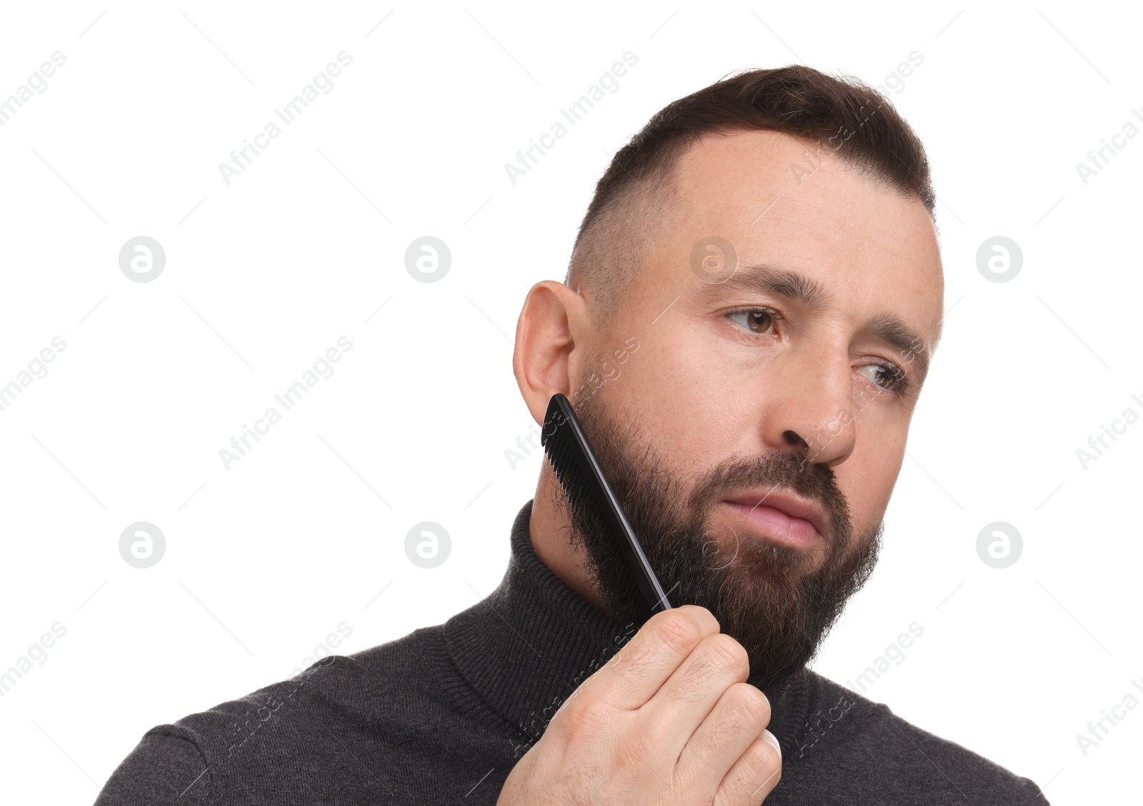 Photo of Handsome man combing beard on white background