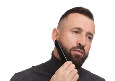 Photo of Handsome man combing beard on white background