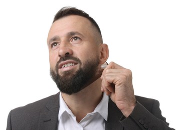 Photo of Handsome man combing beard on white background