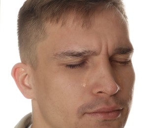 Photo of Distressed young man crying on white background