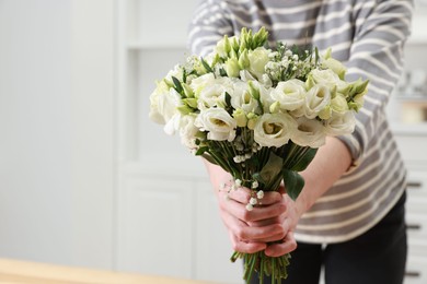 Photo of Florist with beautiful wedding bouquet indoors, closeup. Space for text