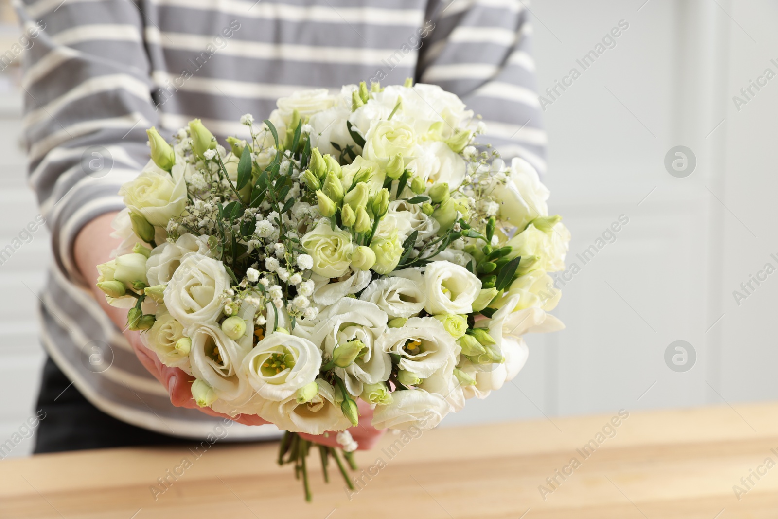 Photo of Florist with beautiful wedding bouquet indoors, closeup. Space for text