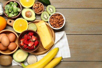 Photo of Different products rich in dopamine on wooden table, flat lay. Space for text