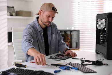 Photo of Man installing computer chip onto motherboard at white table