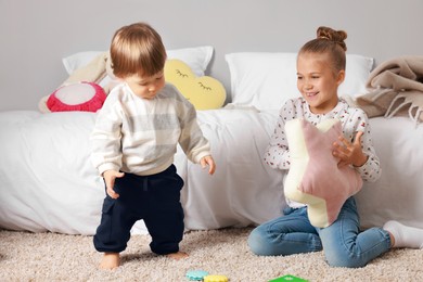 Photo of Sister and brother spending time together on floor indoors