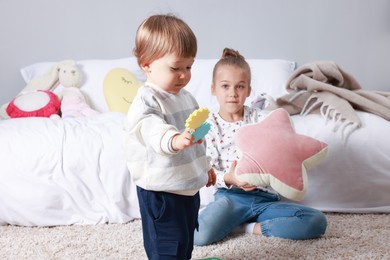 Photo of Sister and brother spending time together on floor indoors