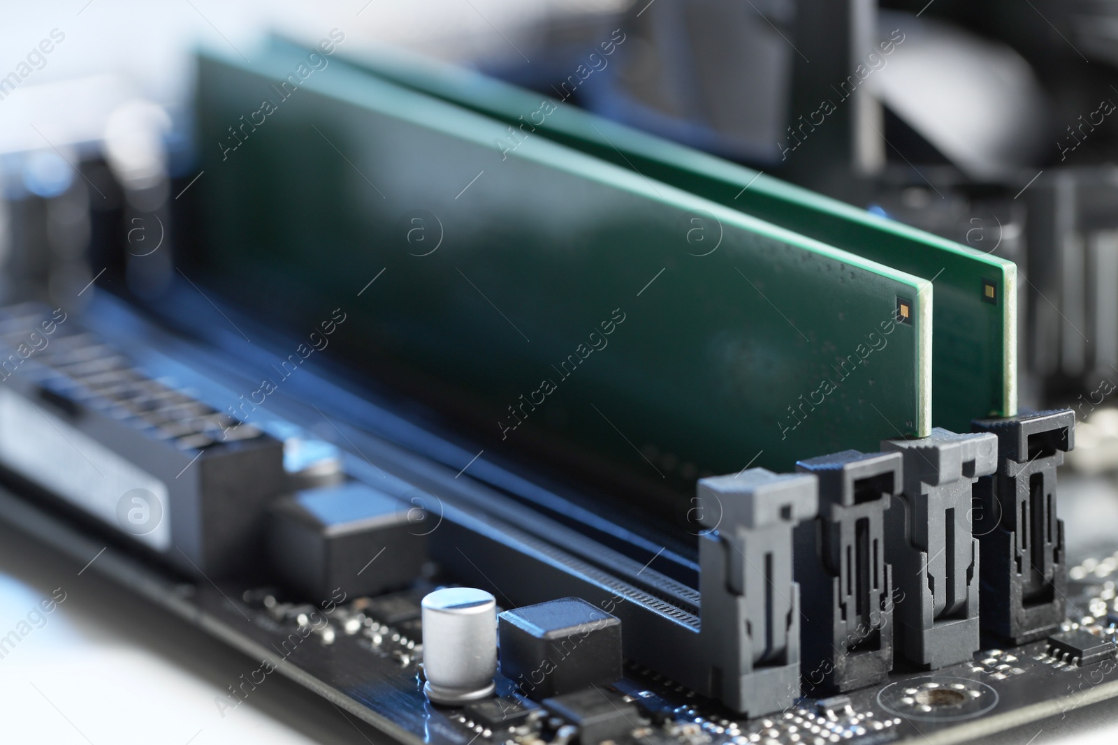 Photo of Computer motherboard with RAM chip on table, closeup. Electronic engineering