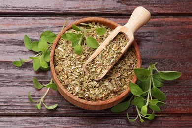 Photo of Dried oregano in bowl, scoop and green leaves on wooden table, top view