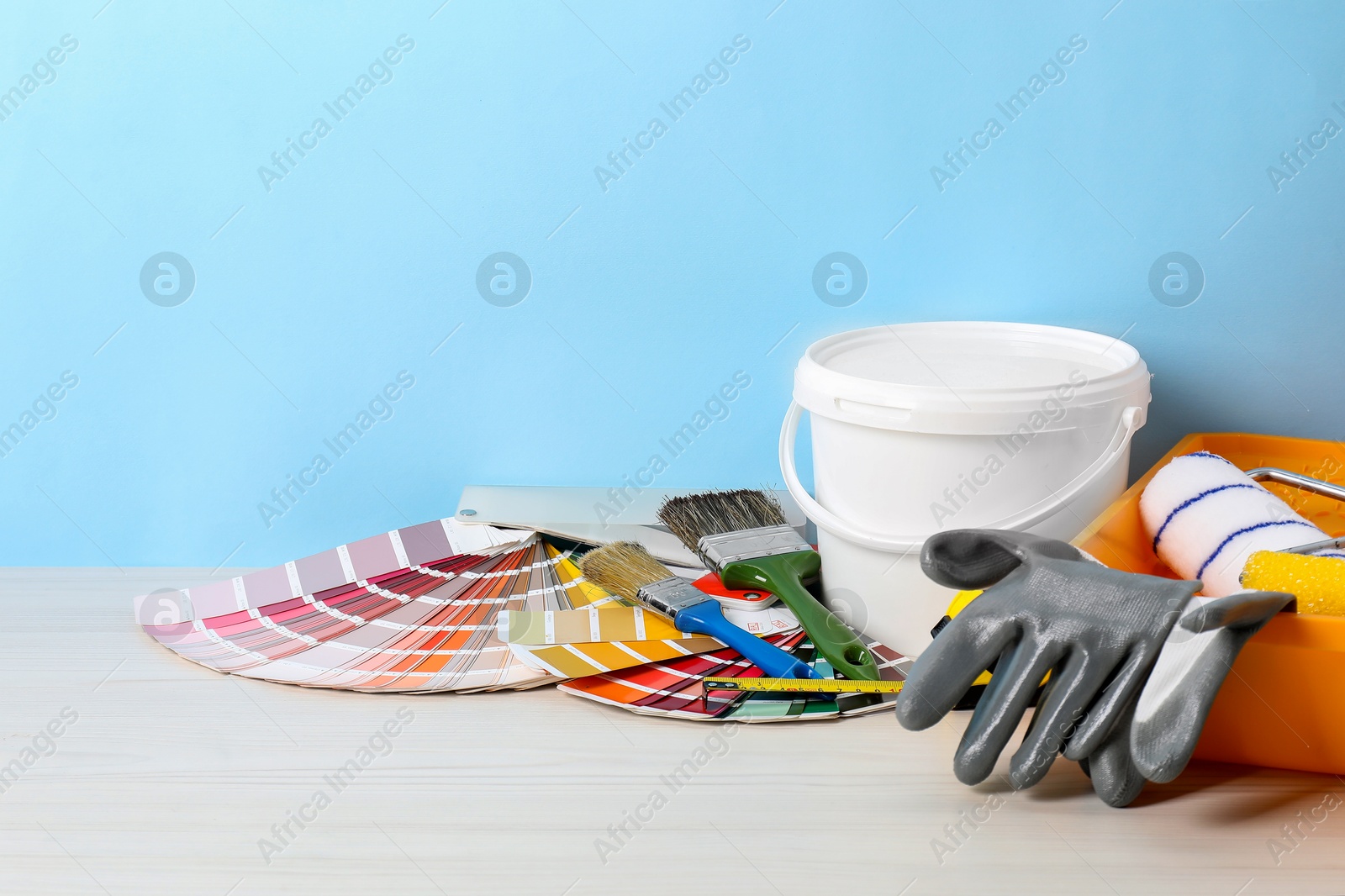 Photo of Different painter's tools on white wooden table, space for text. Decorating and design