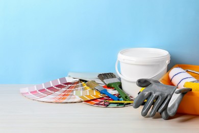 Photo of Different painter's tools on white wooden table, space for text. Decorating and design