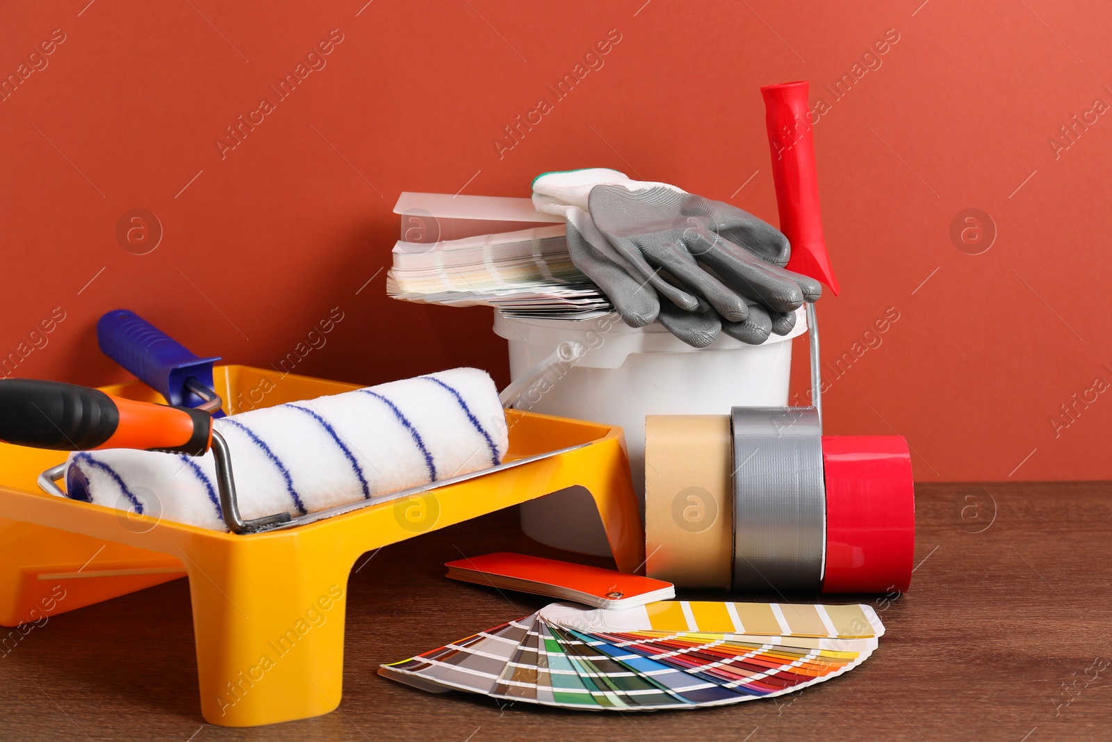 Photo of Different painter's tools on wooden table. Decorating and design