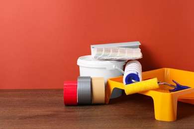 Photo of Different painter's tools on wooden table, space for text. Decorating and design