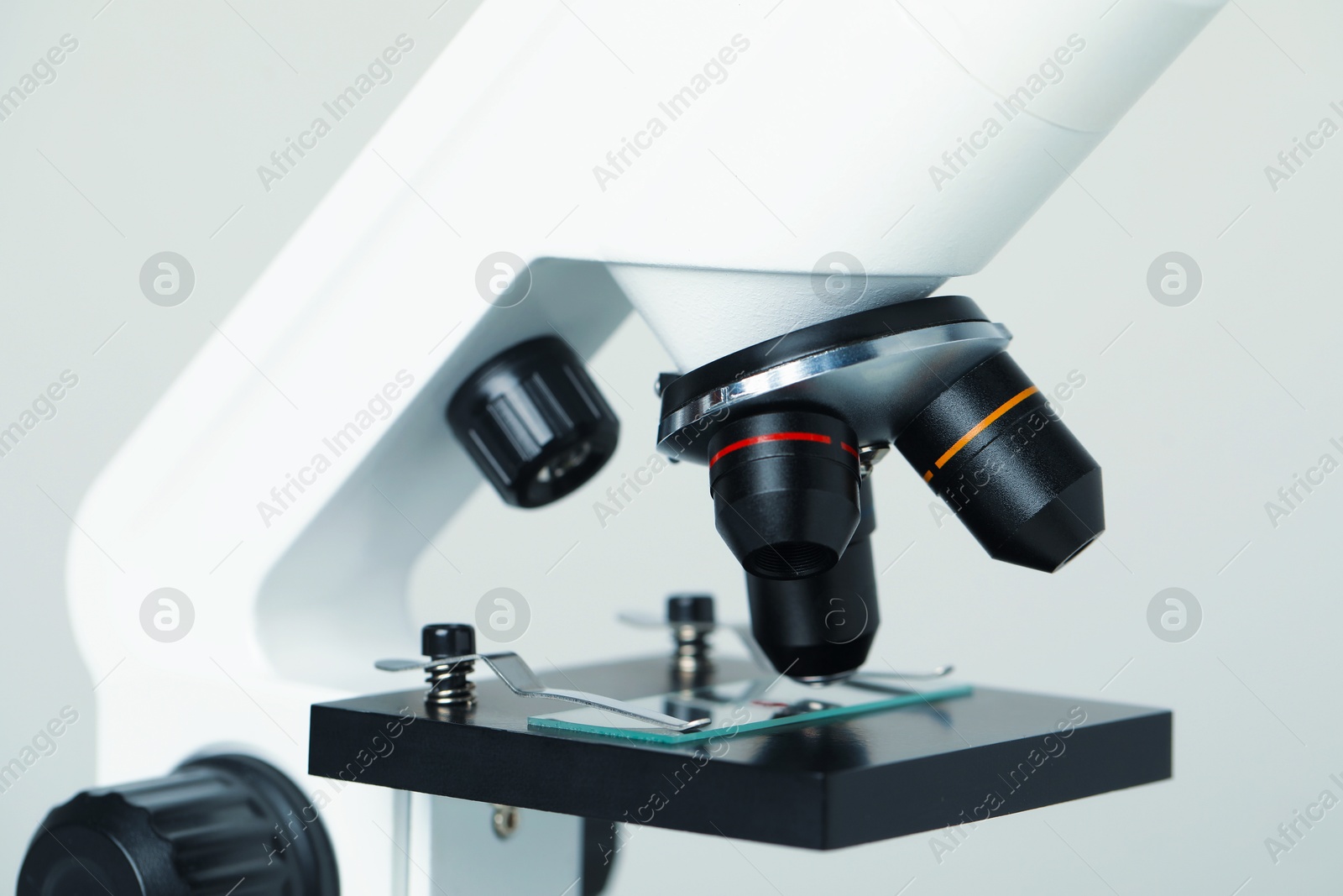 Photo of Science. Microscope with glass slide on light grey background, closeup