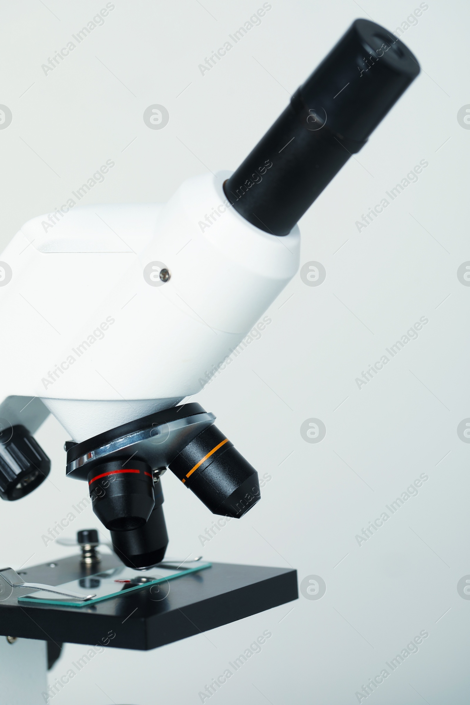 Photo of Science. Microscope with glass slide on light grey background, closeup