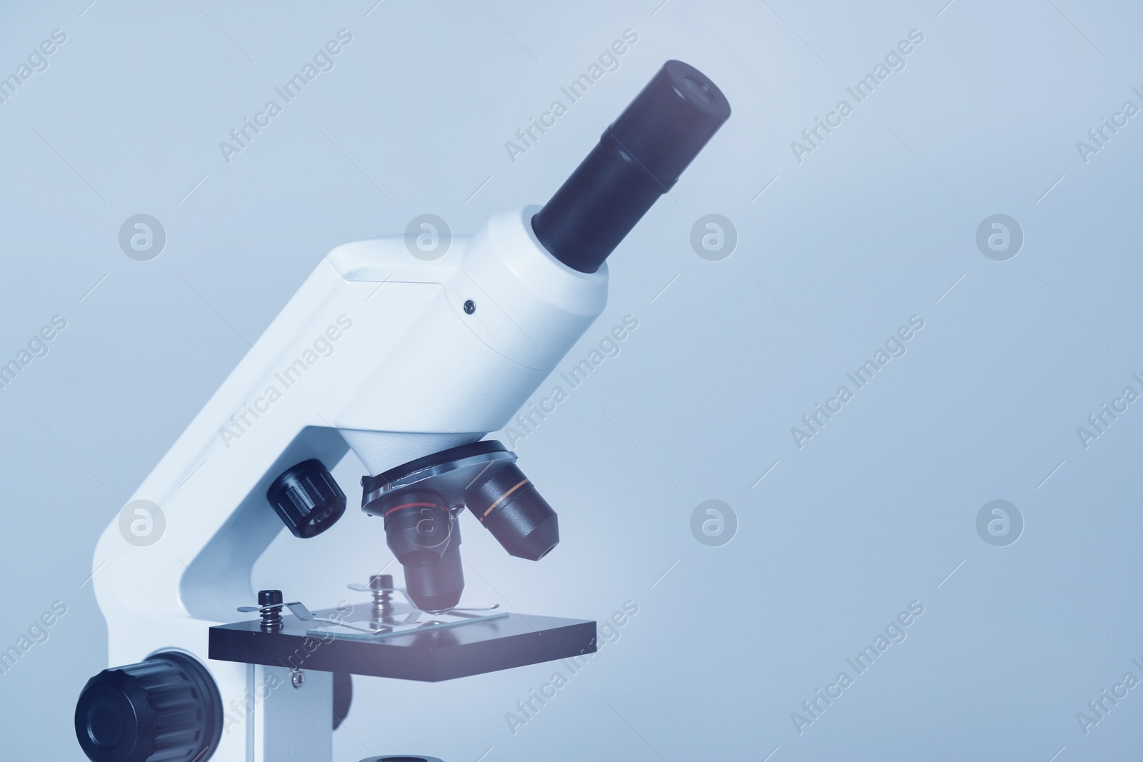 Photo of Science. Microscope with glass slide on light grey background, closeup. Space for text