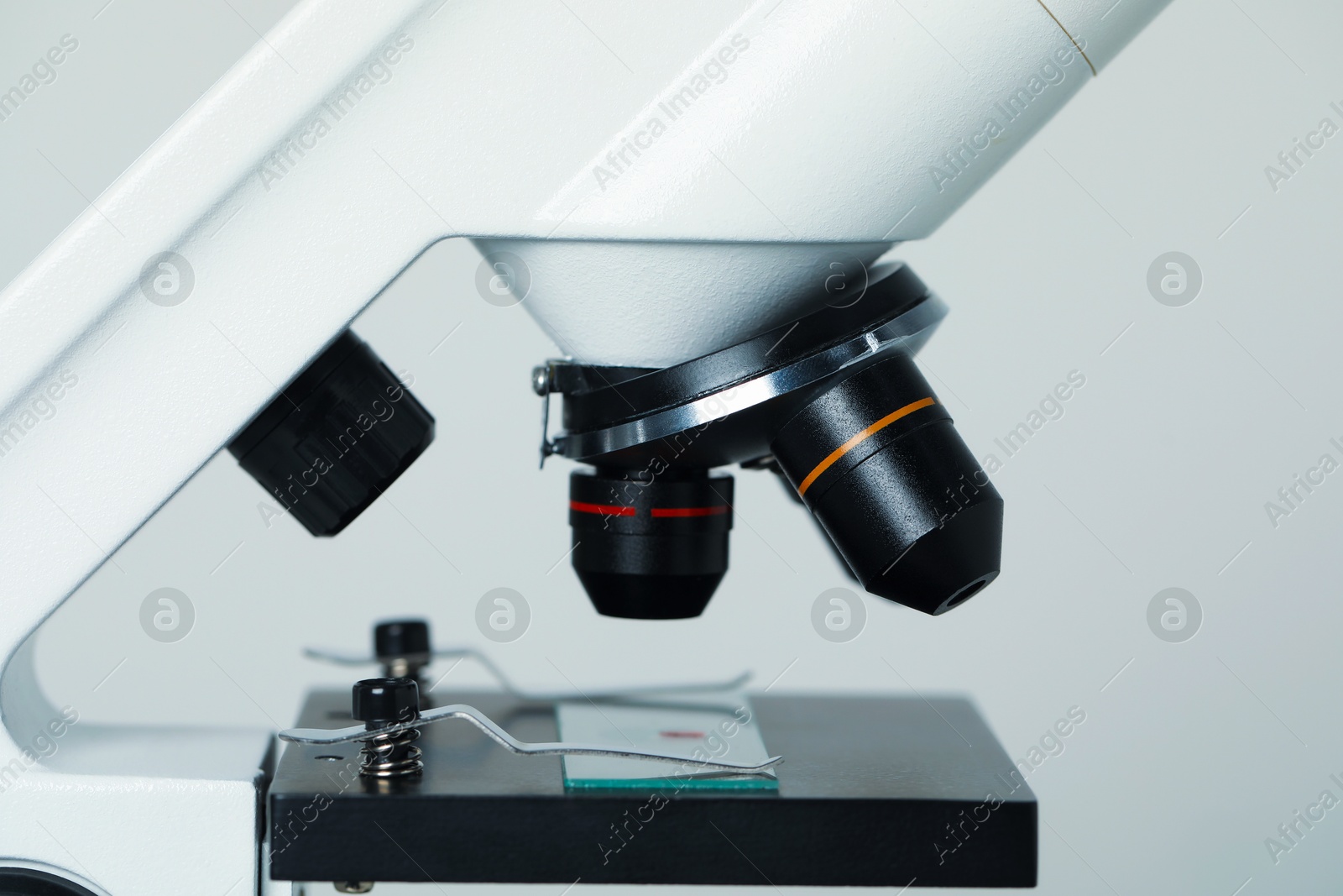 Photo of Science. Microscope with glass slide on light grey background, closeup