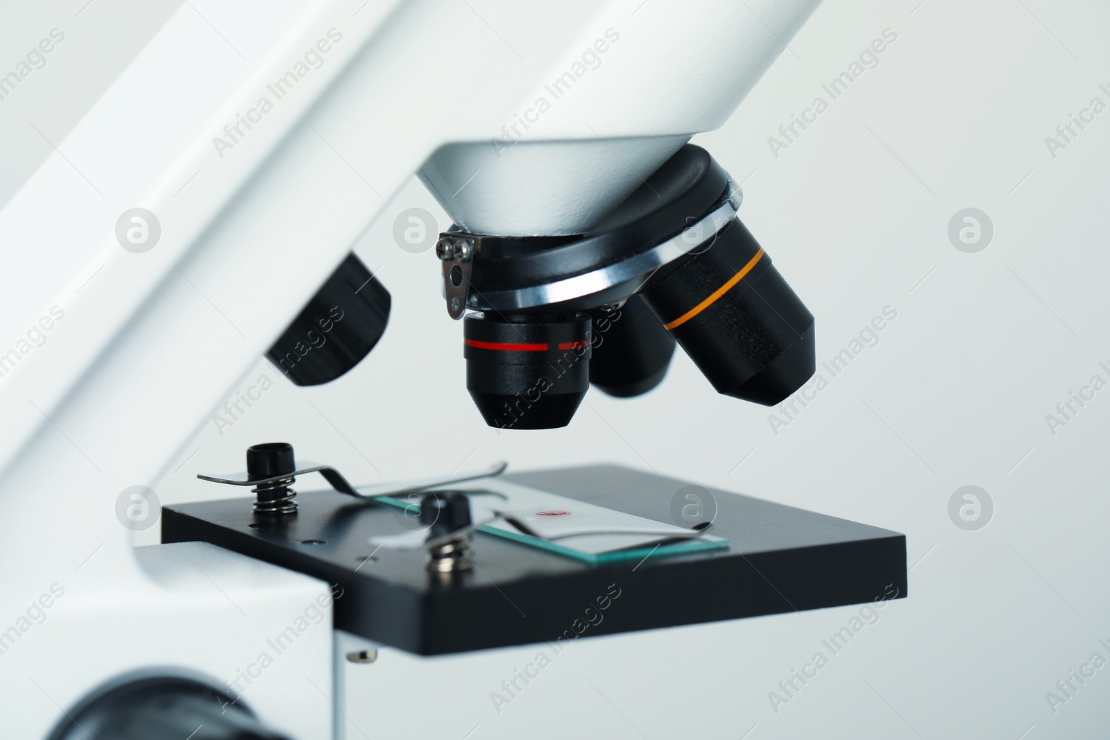 Photo of Science. Microscope with glass slide on light grey background, closeup