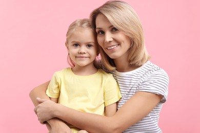 Photo of Cute little girl with her mom on pink background. Happy Mother's Day