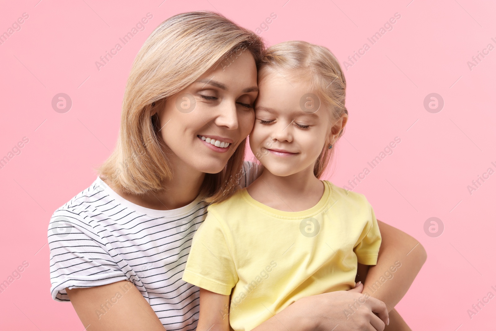 Photo of Cute little girl with her mom on pink background. Happy Mother's Day