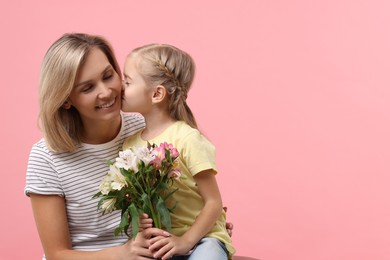 Photo of Little daughter congratulating her mom with bouquet of alstroemeria flowers on pink background, space for text. Happy Mother's Day