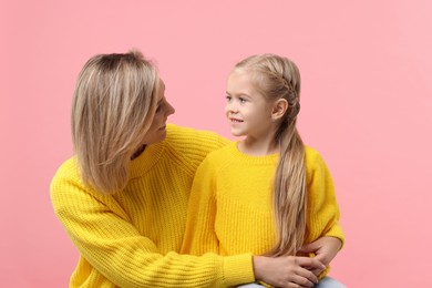 Photo of Cute little girl with her mom on pink background. Happy Mother's Day