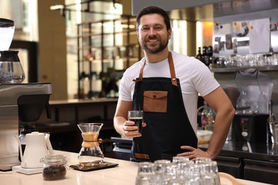 Photo of Barista with aromatic filter coffee at table in cafe