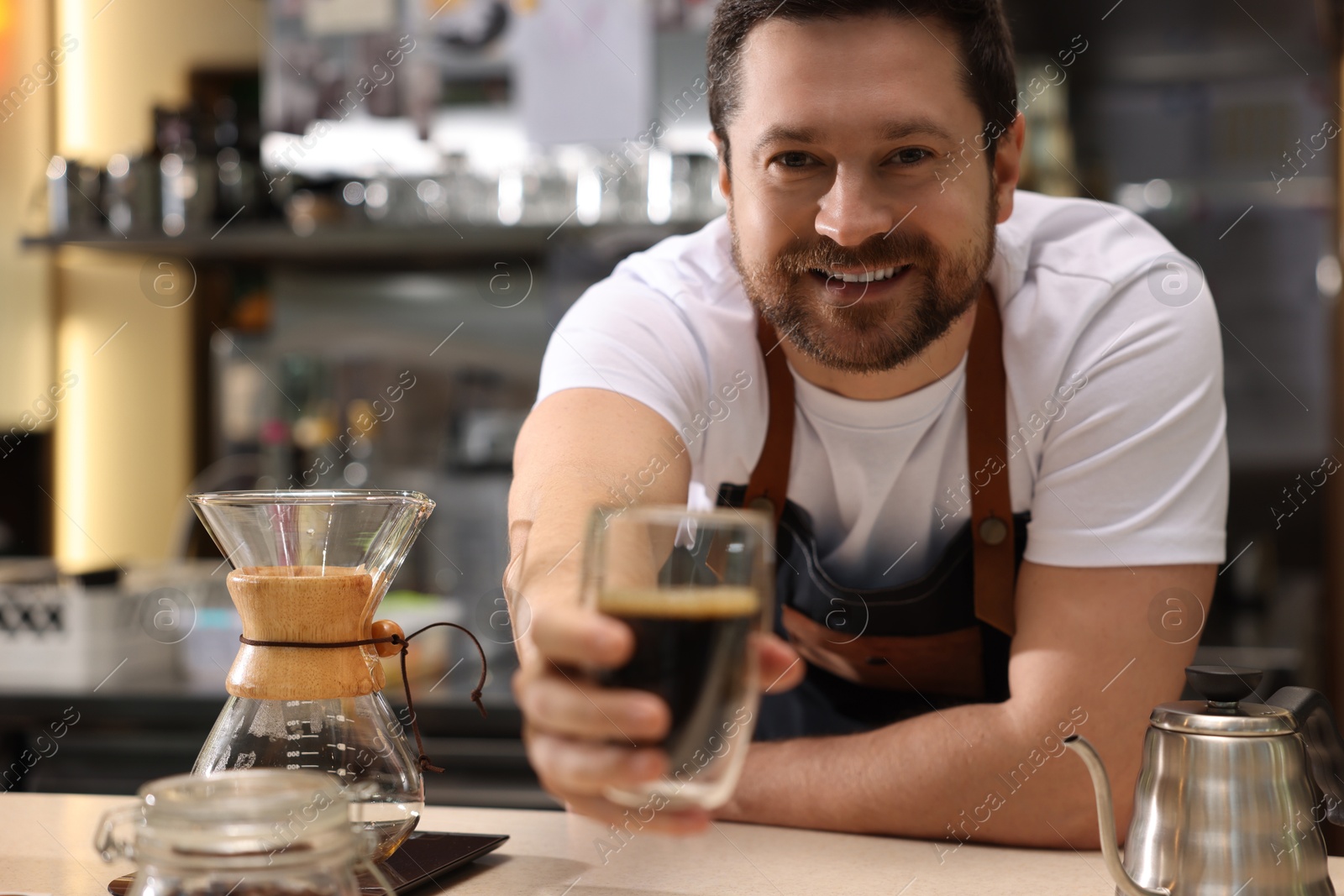 Photo of Barista suggesting cup of aromatic filter coffee in cafe, selective focus