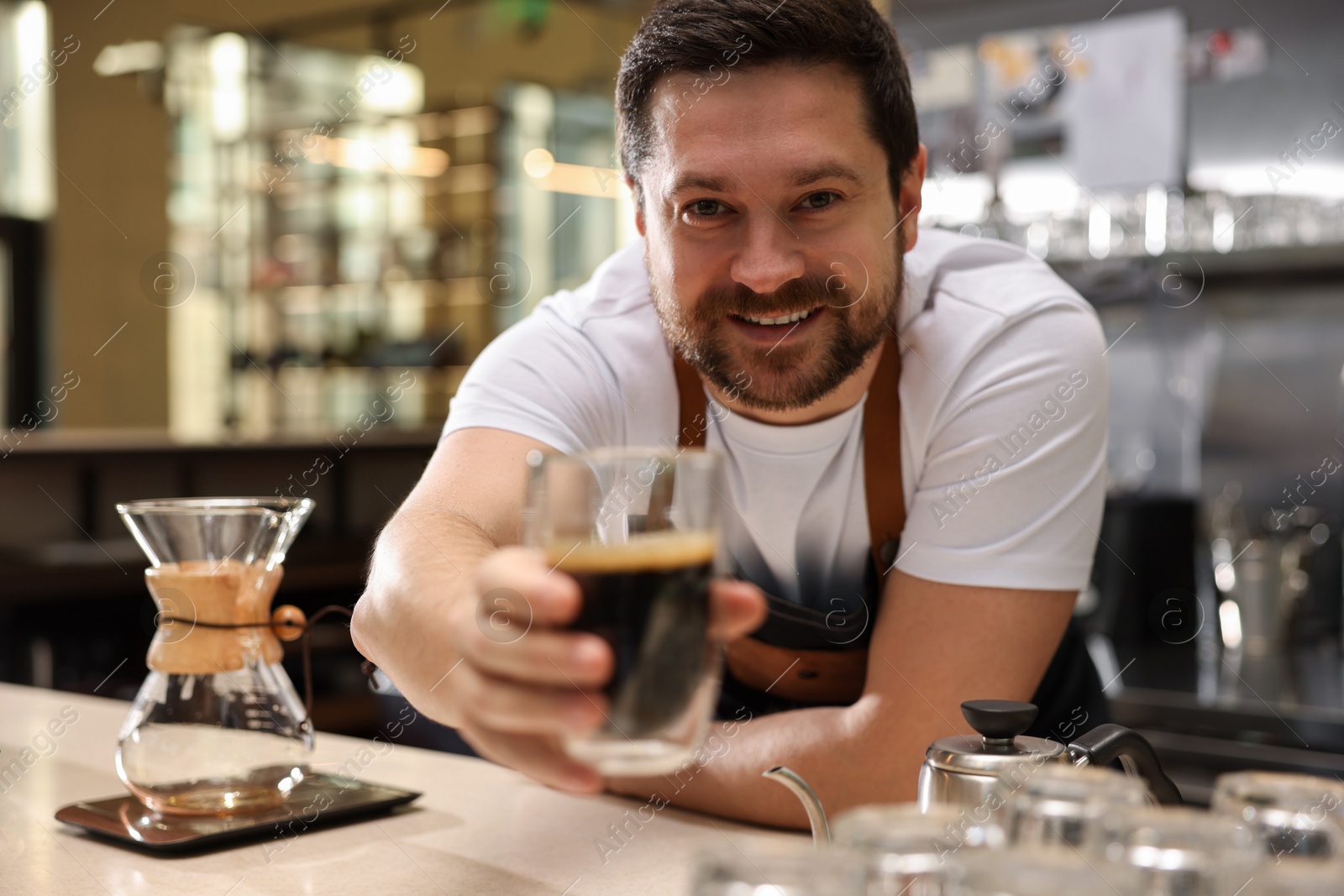 Photo of Barista suggesting cup of aromatic filter coffee in cafe, selective focus