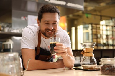 Photo of Barista with aromatic filter coffee at table in cafe