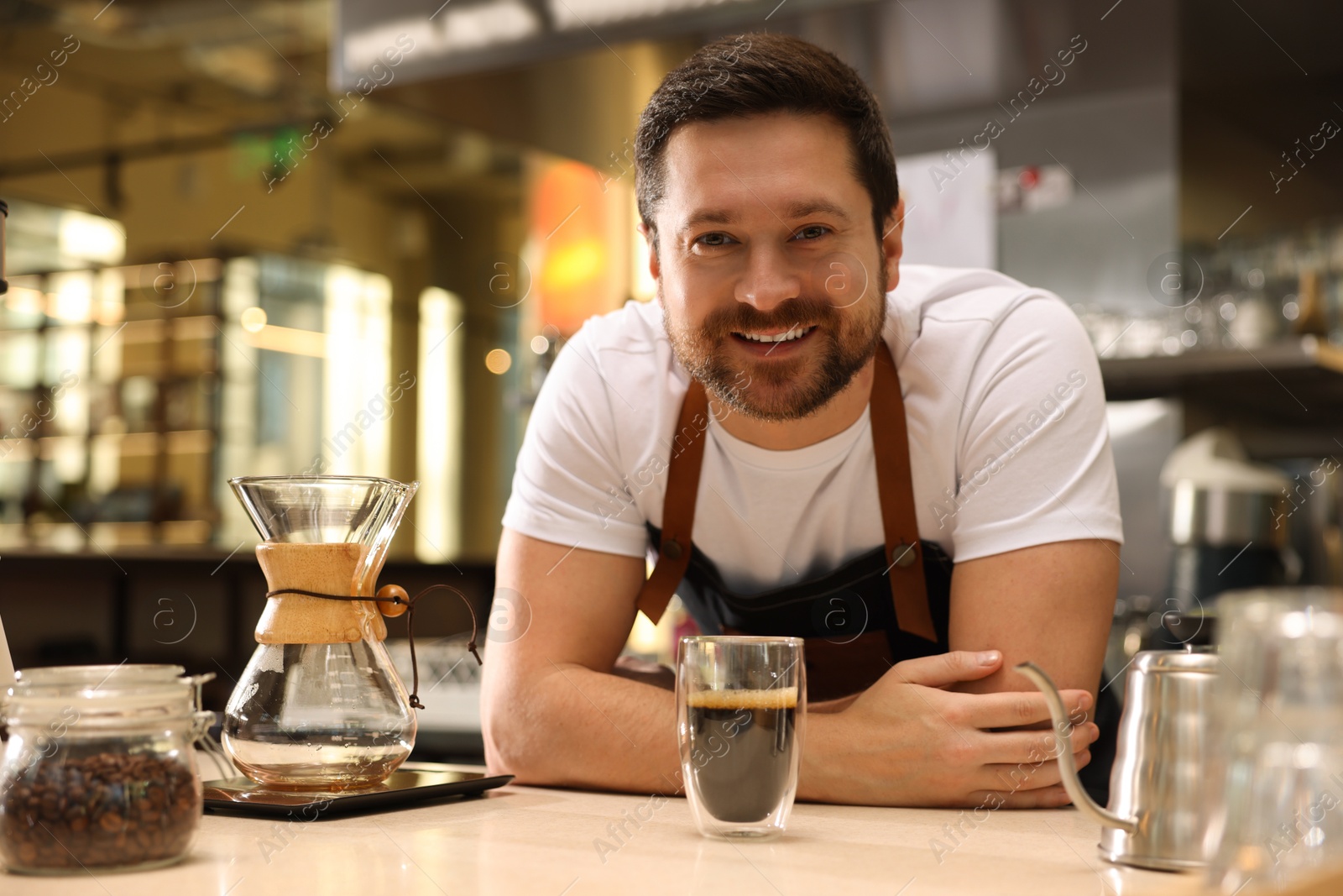 Photo of Barista with aromatic filter coffee at table in cafe