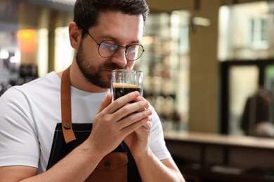 Photo of Barista sniffing aromatic filter coffee in cafe