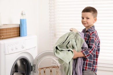 Little helper. Cute boy doing laundry at home