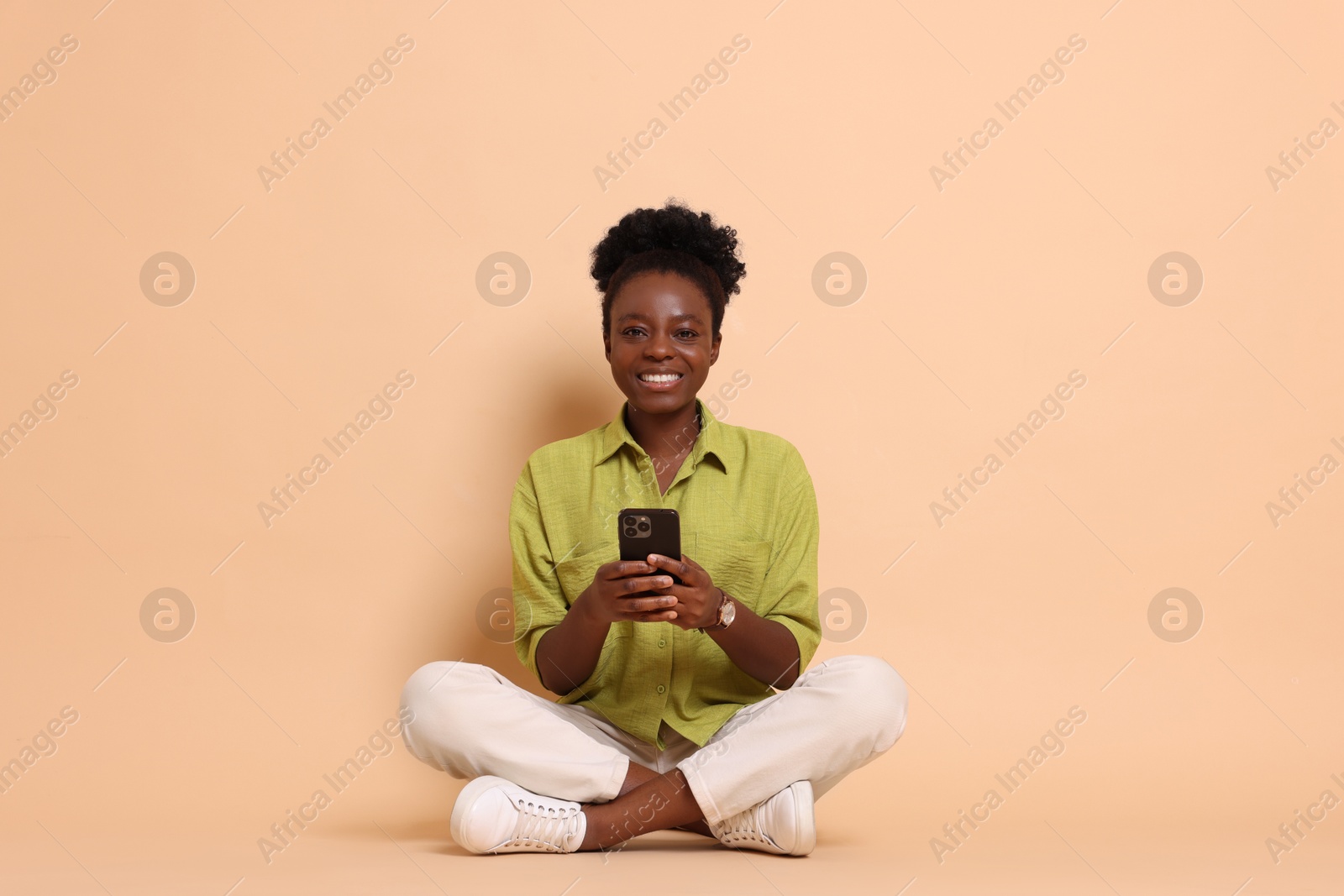 Photo of Happy woman with smartphone on beige background. Space for text