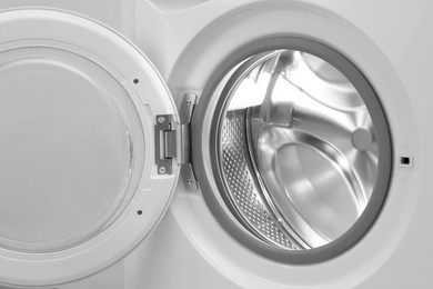 Photo of Washing machine with empty drum as background, closeup