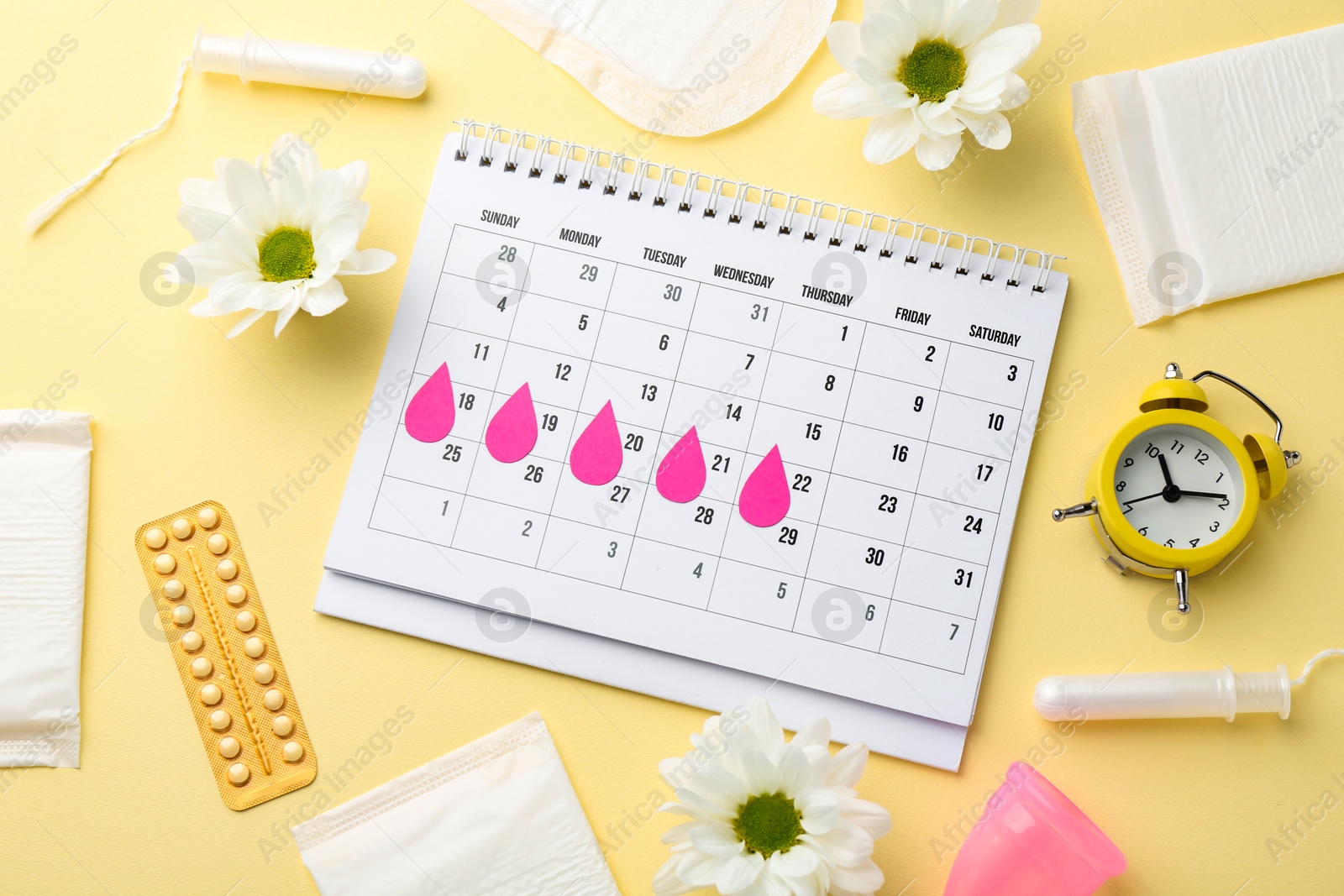 Photo of Flat lay composition with calendar and menstrual products on beige background