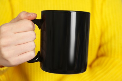 Photo of Woman with black ceramic cup, closeup. Mockup for design