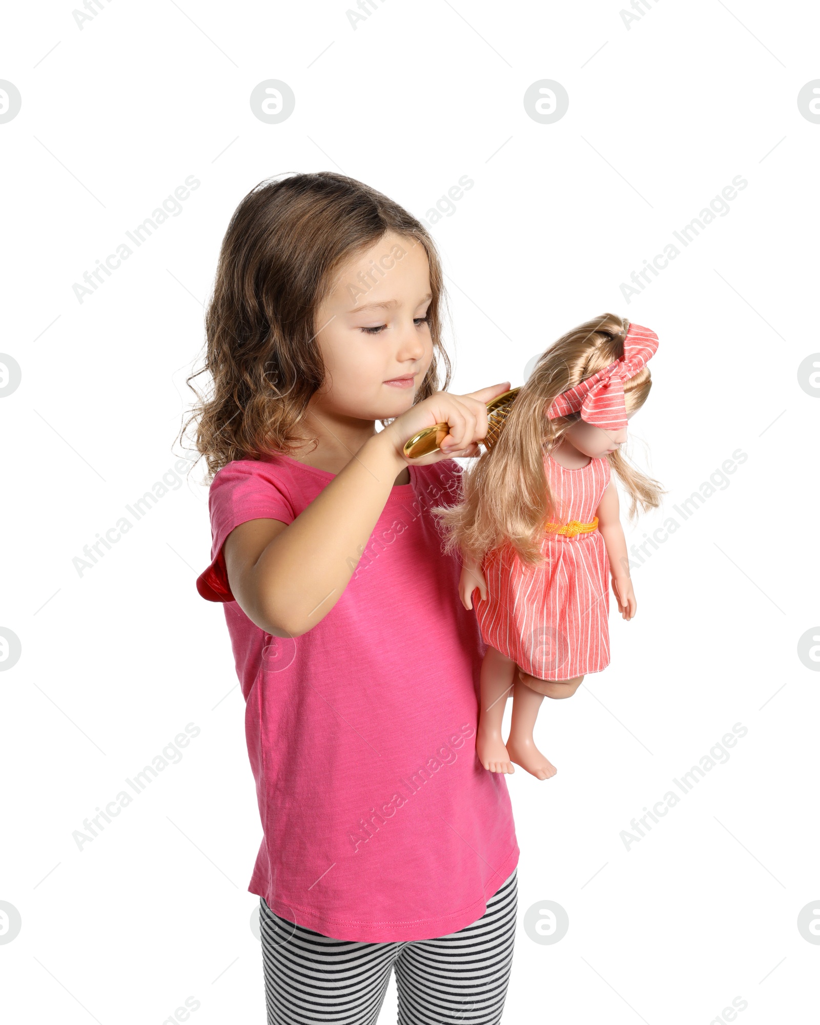 Photo of Cute little girl brushing doll's hair on white background