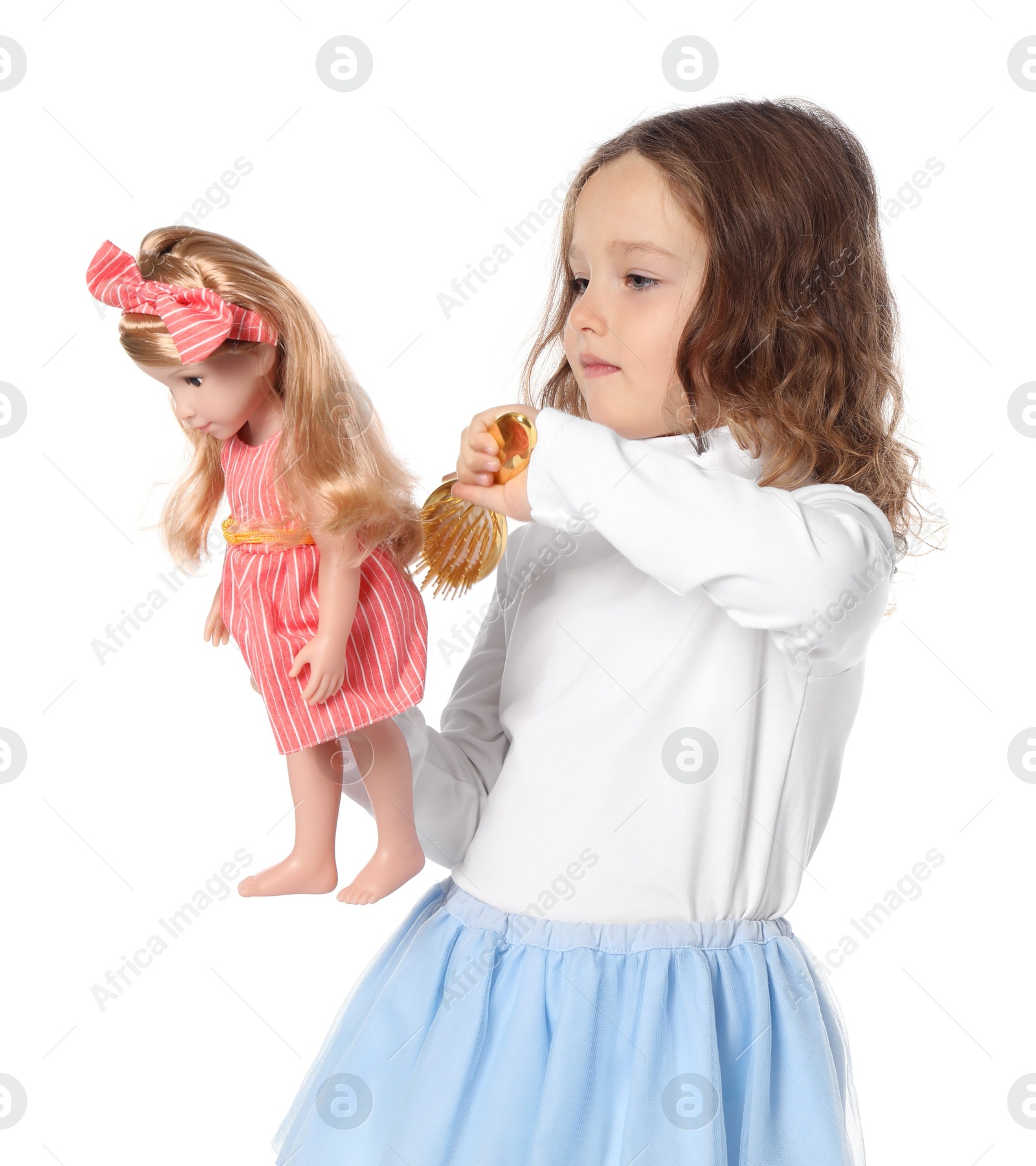 Photo of Cute little girl brushing doll's hair on white background